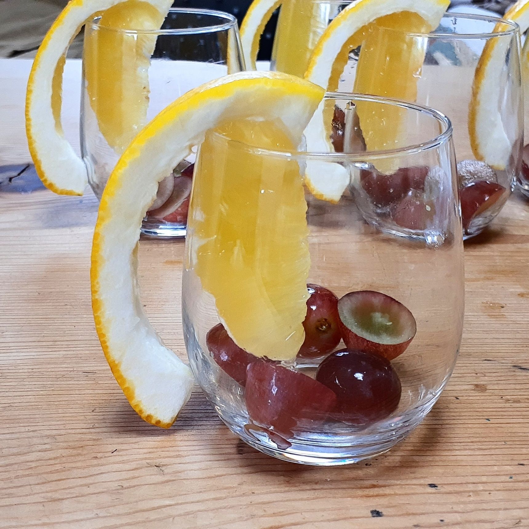 ②カットした柑橘をグラスの縁に…ぶどうを中に…そしてレモンゼリーを注いで、少し固まるまで待つ。