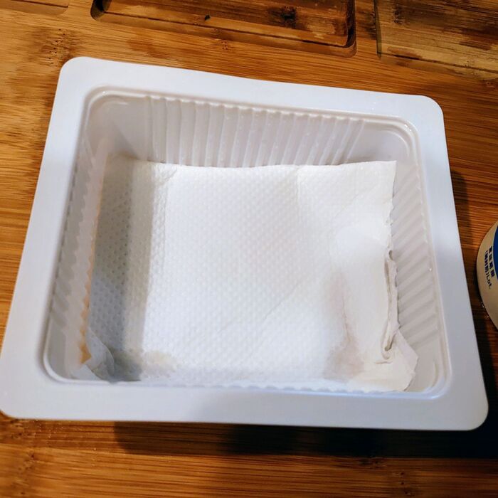 お豆腐の容器に、厚めにキッチンペーパーを敷きます