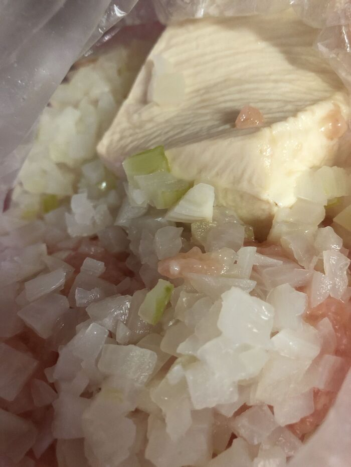 ビニール袋に入れたひき肉に塩を振って練り、豆腐、玉ねぎを加え こねます