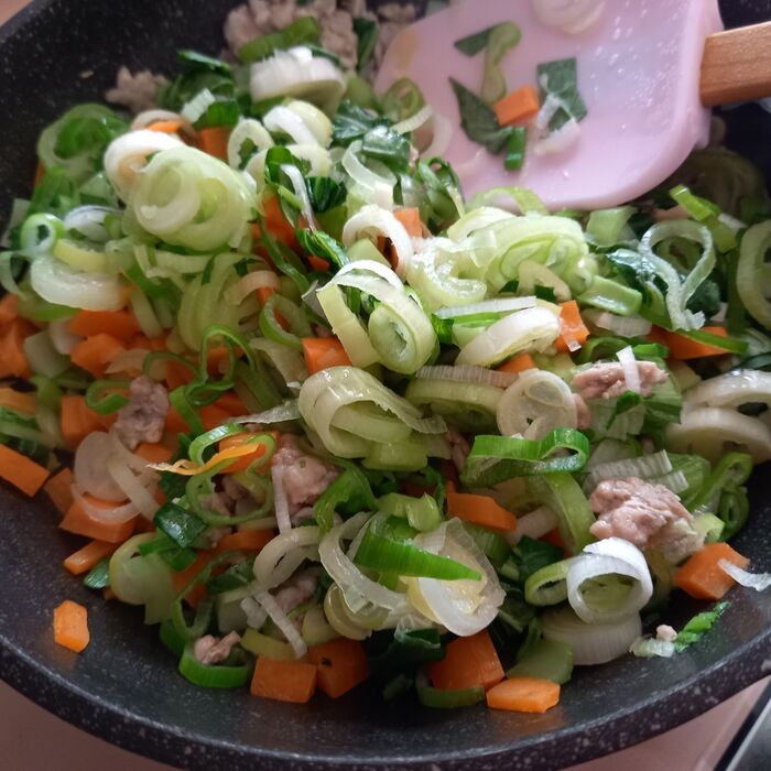 刻んだ野菜とひき肉を炒める