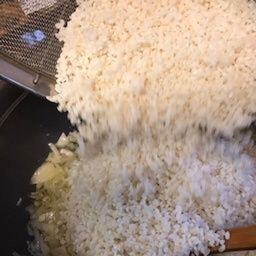 オリーブオイルで玉ねぎとニンニクを炒め米を入れます