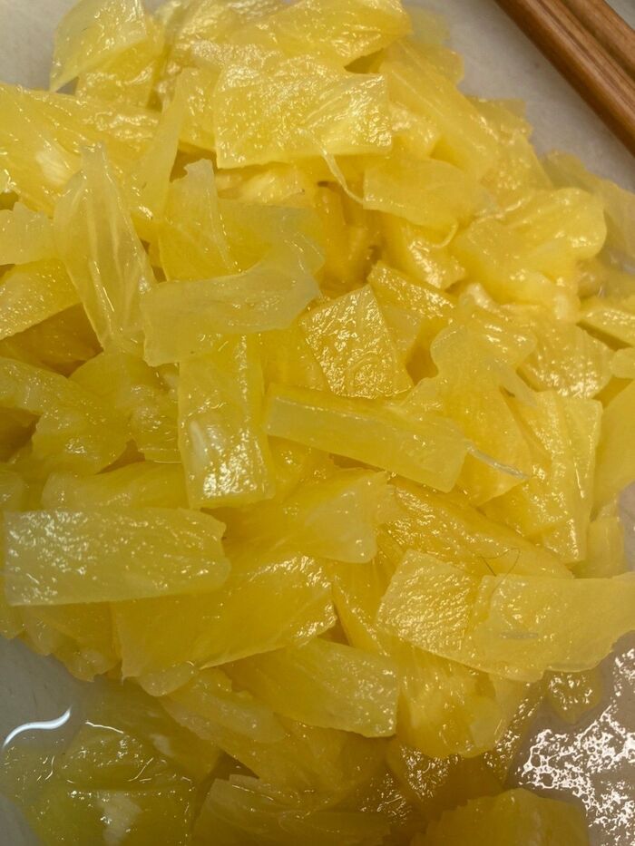 刻んだ缶詰のパイナップルを加え,レモンのしぼり汁を加えて混ぜ合わせます