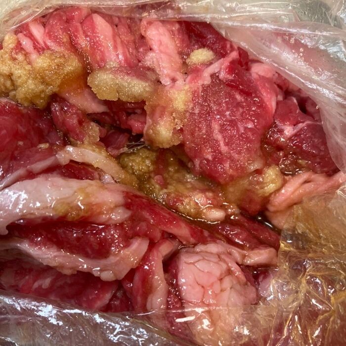 ビニール袋に牛肉と調味料、生姜、ニンニクを入れて揉み込む