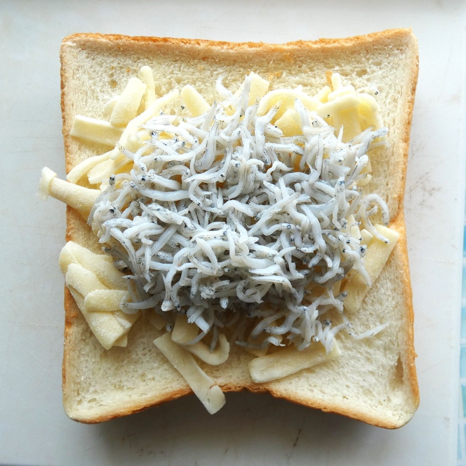 食パンに溶けるチーズ・しらすを乗せてトースターで焼きます。