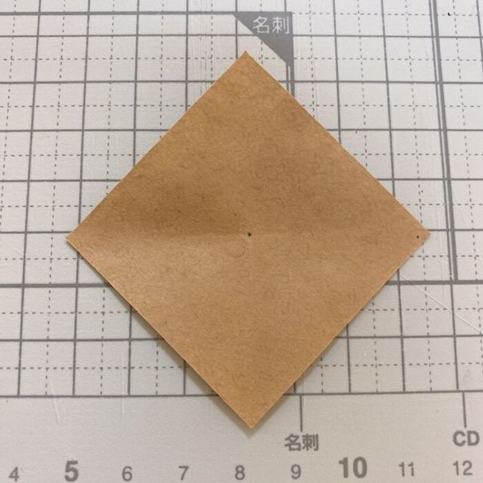 クラフト紙を正方形に切って、真ん中に印をつける。