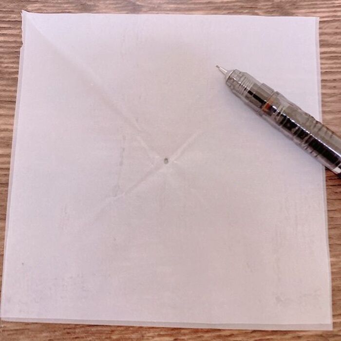 正方形の紙の対角線上の真ん中に印をつけます。