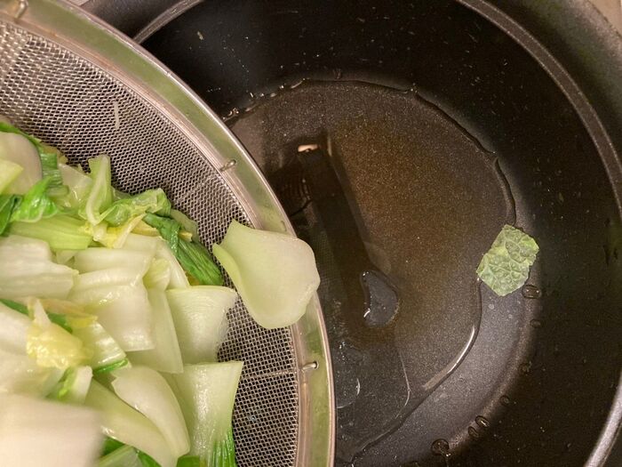 汁を開けた鍋にサラダオイルとごま油を入れてすぐに野菜を戻します
