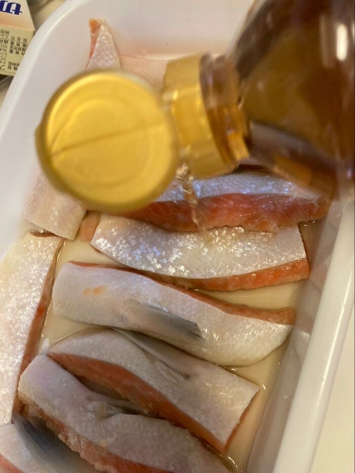 バットに鮭ハラミを並べて白出汁と日本酒をかけて一晩置きます