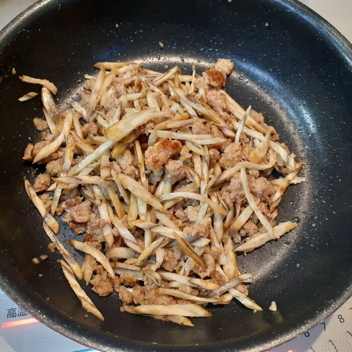 ④ハンバーグを崩し、手順③のごぼう、塩、粗挽き胡椒を加えて炒める