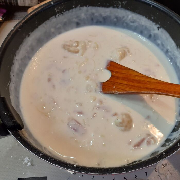 5．中火のまま、牛乳を少量ずつ加えて混ぜながらホワイトソースを作る。