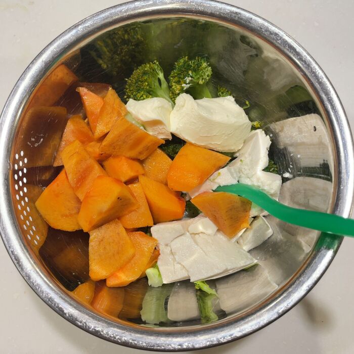 ボウルにブロッコリー、柿、クリームチーズ、豆腐を混ぜます