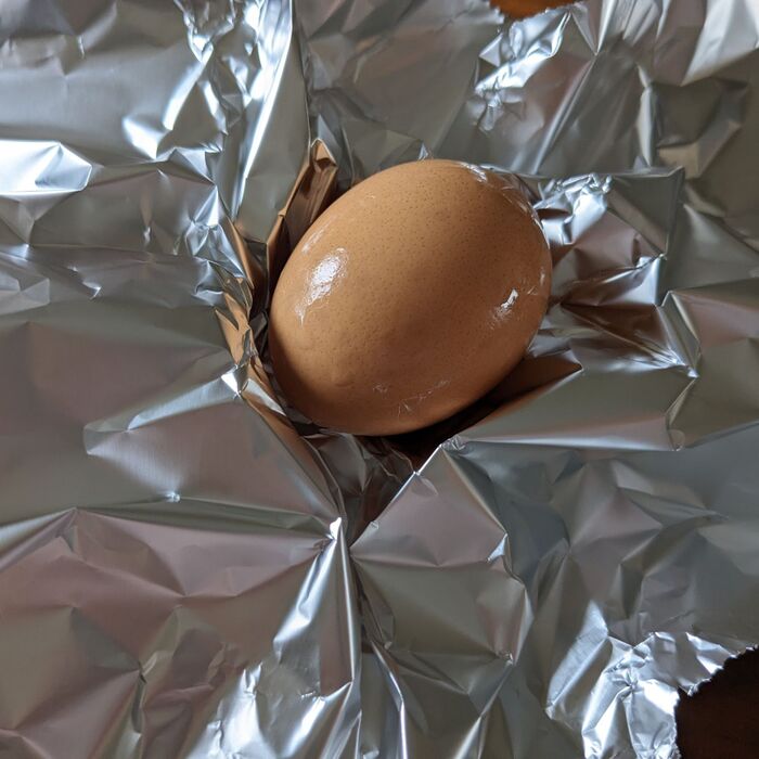 2.卵を水でさっと洗い、アルミホイルで包む。炊飯器に入れる