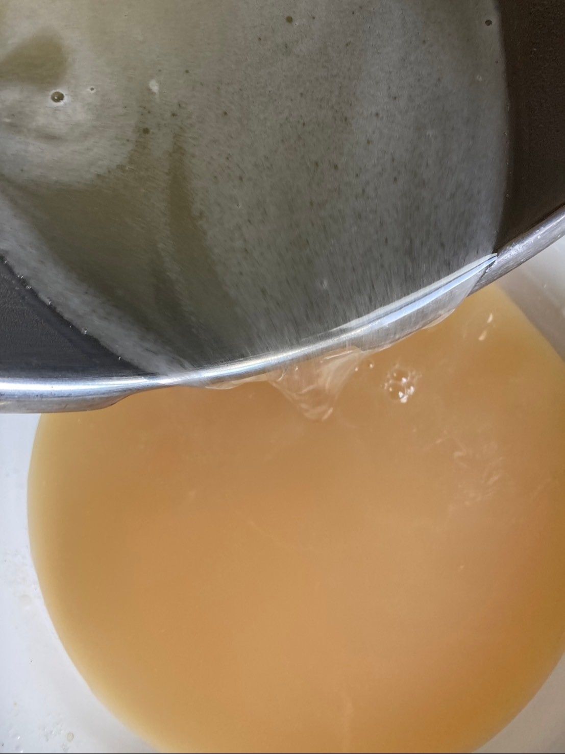 桃の果汁に溶かしたゼラチン液を半分入れて、手早くかき混ぜます