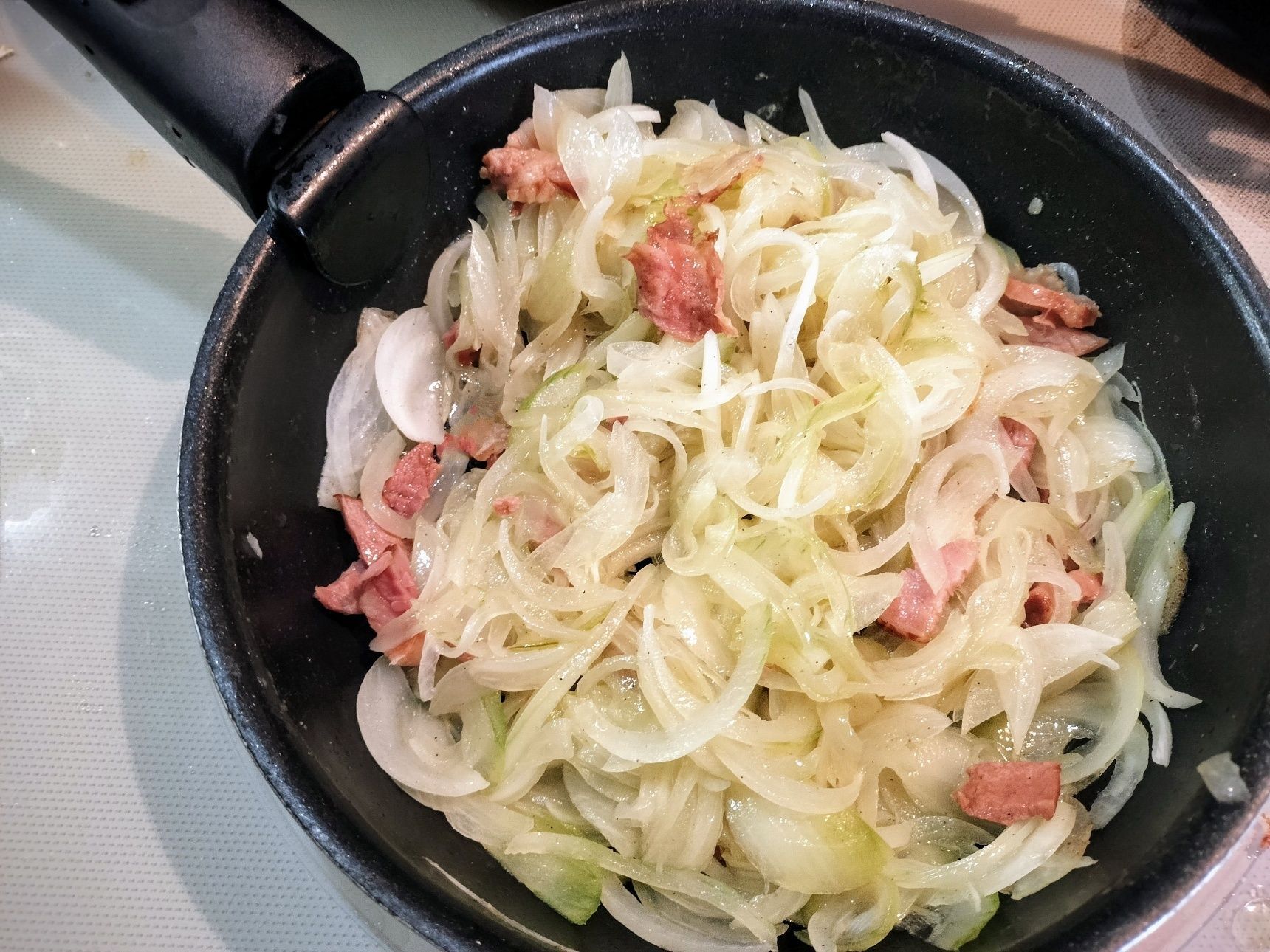 2、（じゃがいもを焼いている間に）玉ねぎの皮を剥き、薄切りする→フライパンにオリーブオイルを入れる→ベーコン・玉ねぎ・塩・粗挽き胡椒を入れて、中火で玉ねぎがしんなりするまで炒める→小麦粉を加えて炒める→牛乳を加えて強火で煮立たせる→煮立ったらすぐに弱火〜中火にしてとろみがつくまで煮る→塩で味を調える