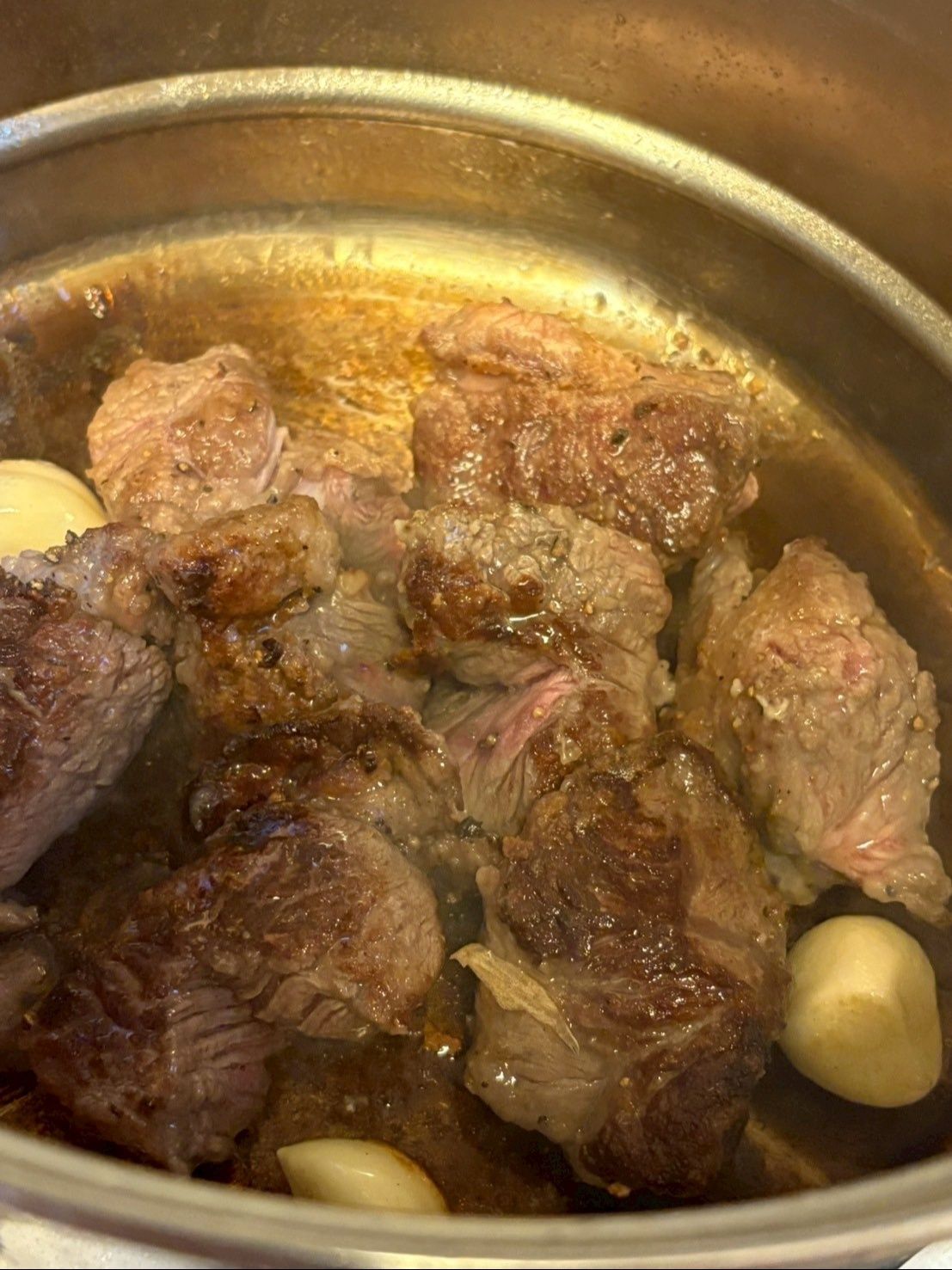 鍋にオリーブオイルを入れニンニクとすね肉の表面に焼き色が付くまで焼きます