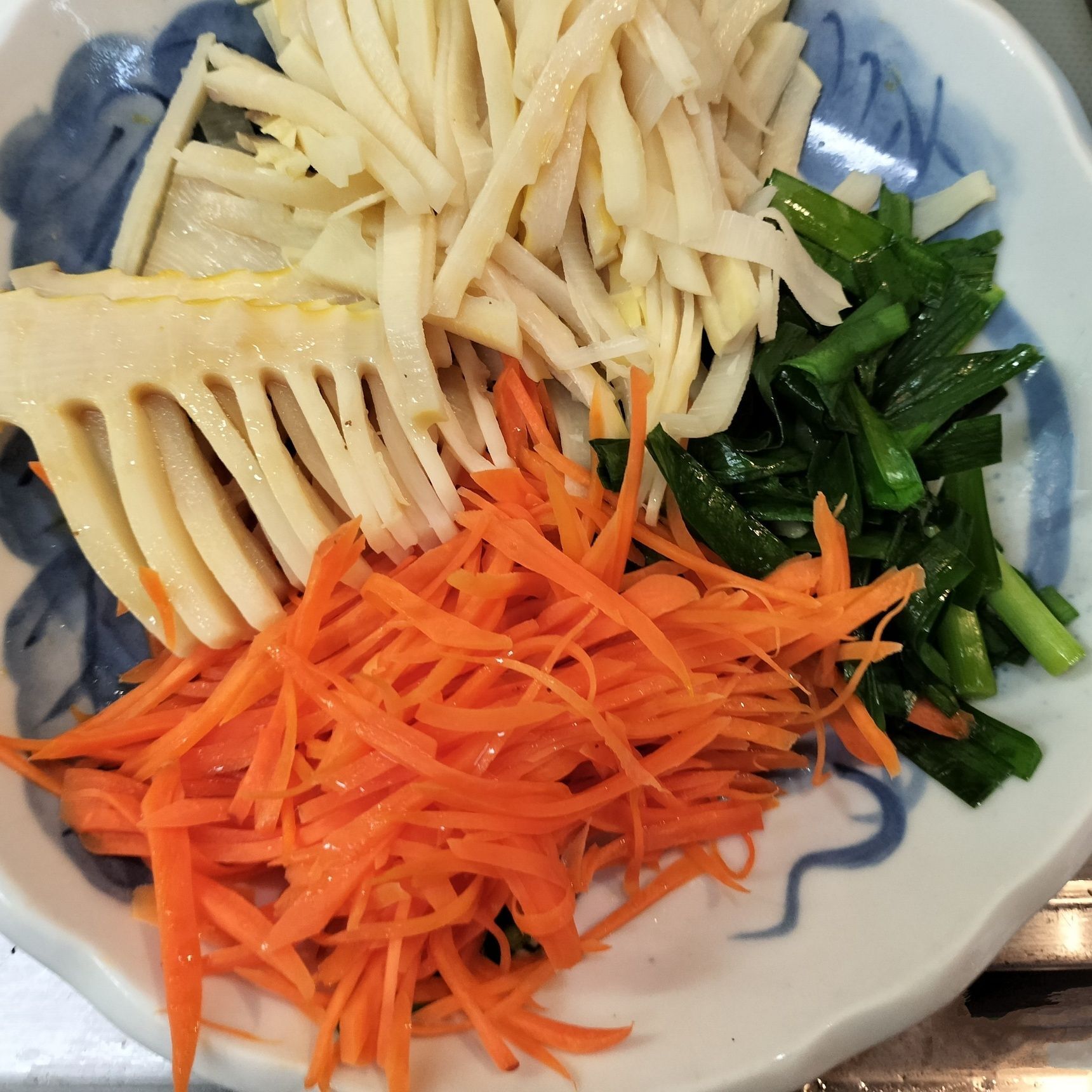 3、たけのことにんじんは千切り、ニラは食べやすい大きさに切る→もやし・たけのこ・にんじん・ニラに、少量の天然塩をふりかけてから電子レンジで数分加熱する→ごま油を、回しかける