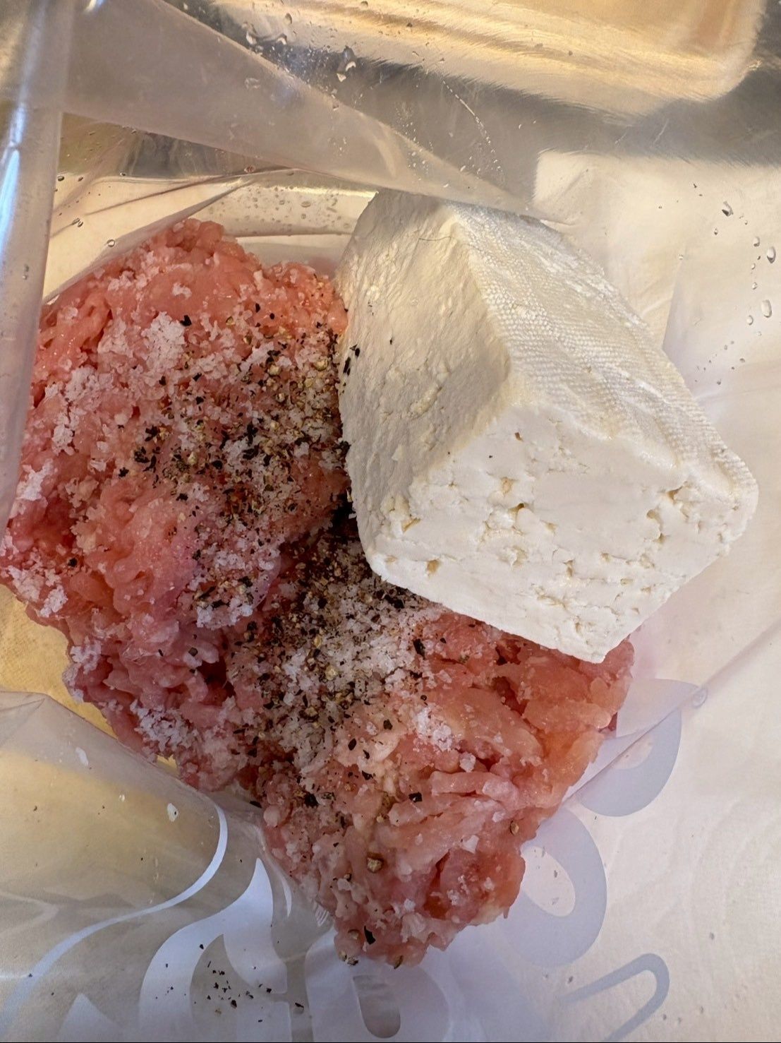 ビニール袋にひき肉を入れ、塩コショウしてから豆腐を入れてよく混ぜ込みます