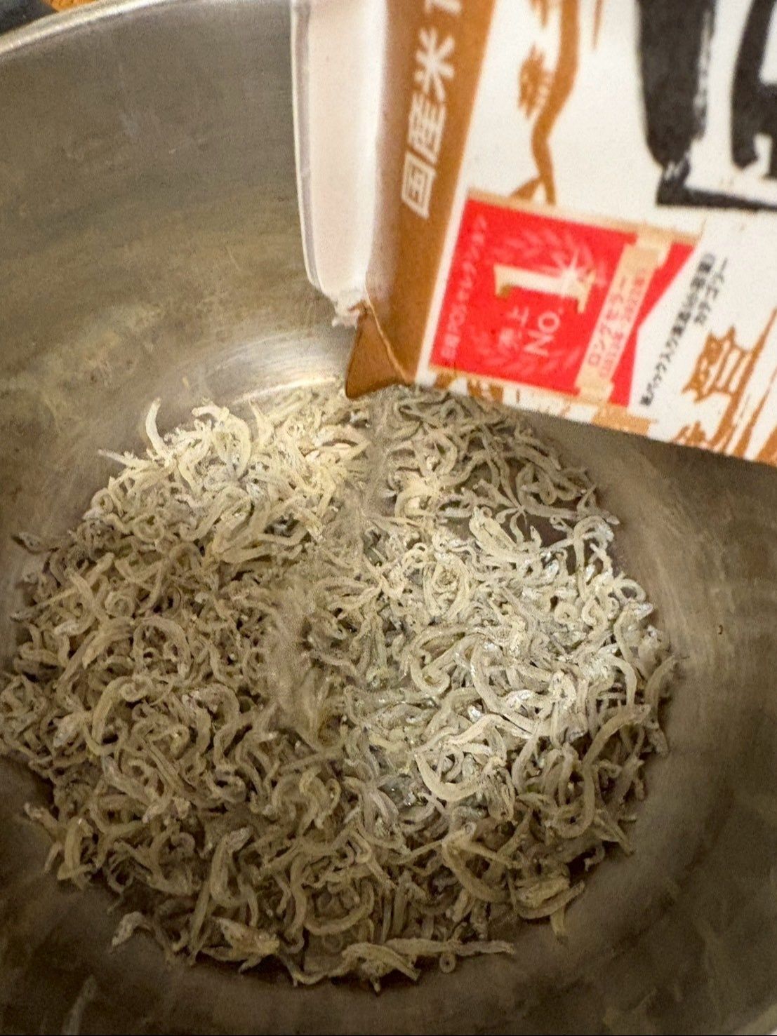 お鍋にじゃこを入れたら、日本酒をかけて中火でふやかします。