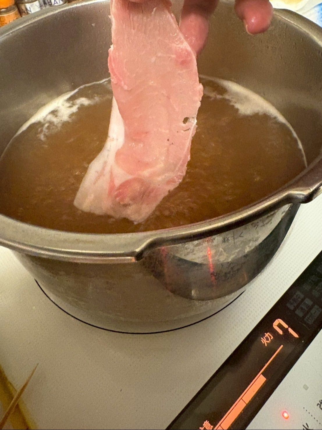 鍋に湯を沸かし固形スープを良く溶かしてからお肉を一枚ずつ入れていきます。
