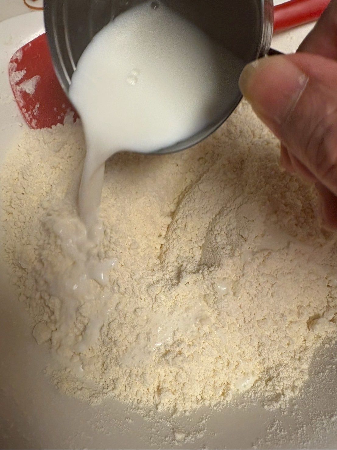 牛乳を50ccずつ2回に分けて加え、切るようにさっくり混ぜます。