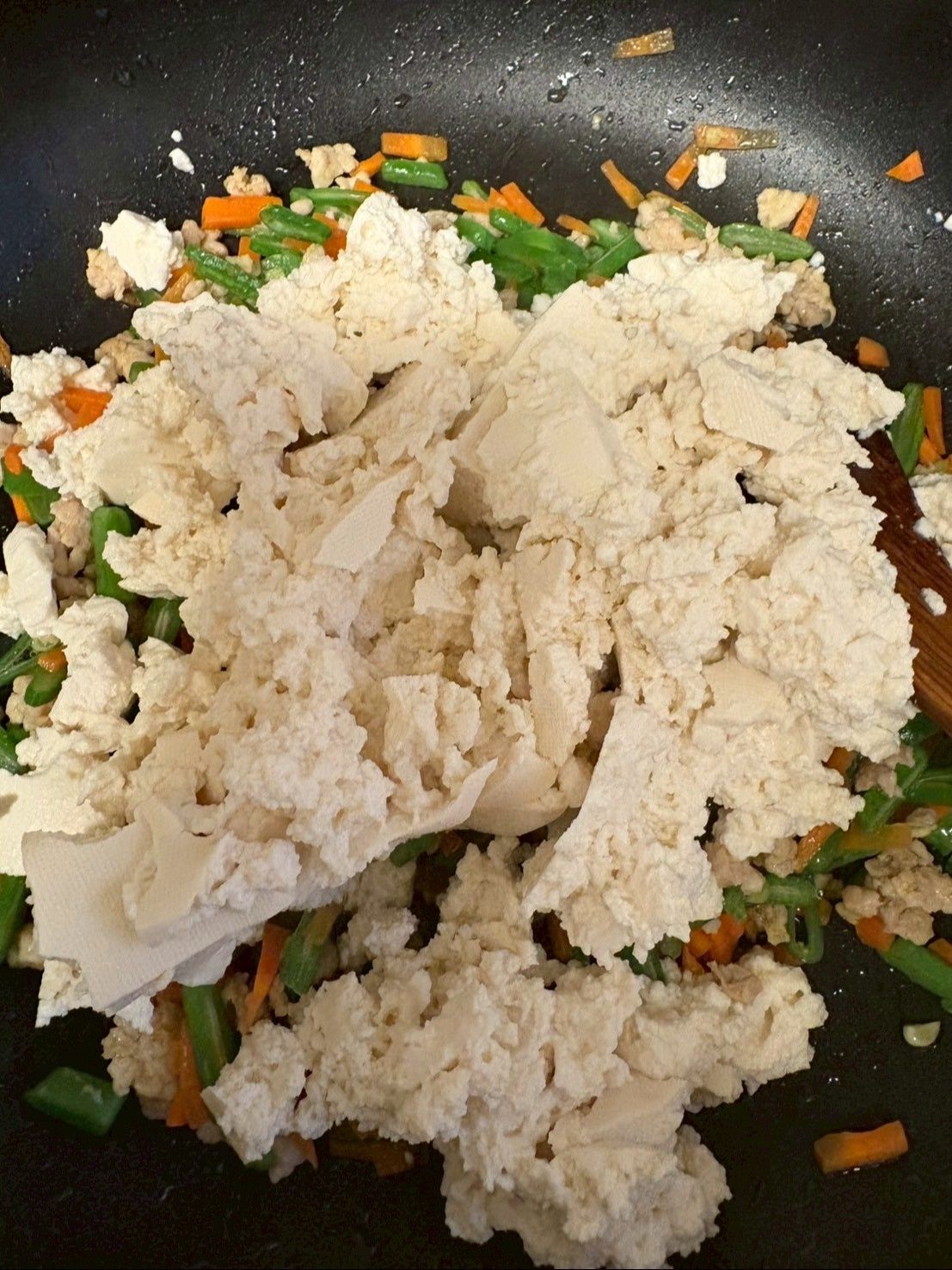 水気を切った木綿豆腐を手でちぎって加え炒め合わせます。