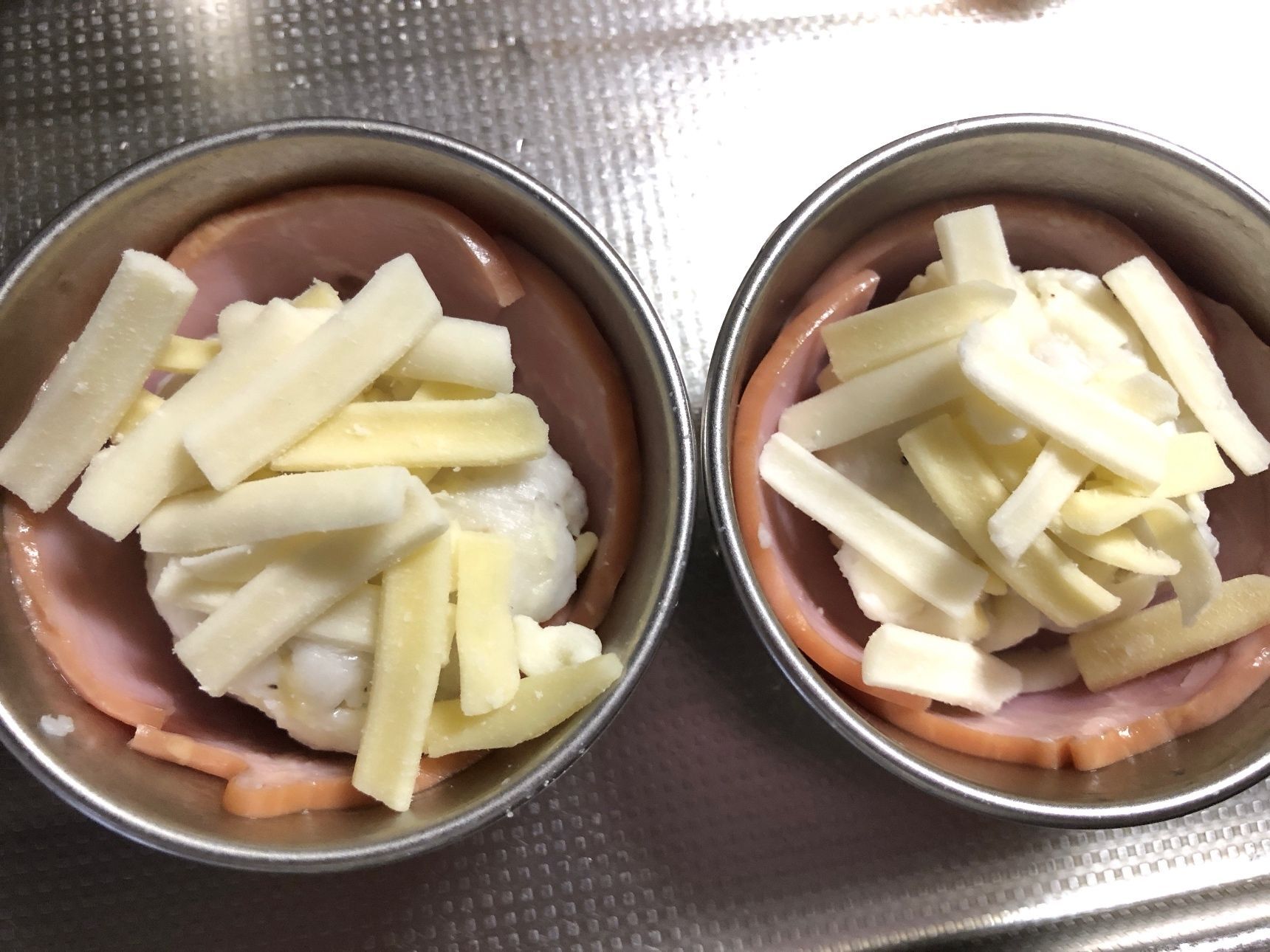 はんぺんとピザ用チーズを混ぜた物を成形しハムカップに入れ、ピザ用チーズ（トッピング用）をのせます