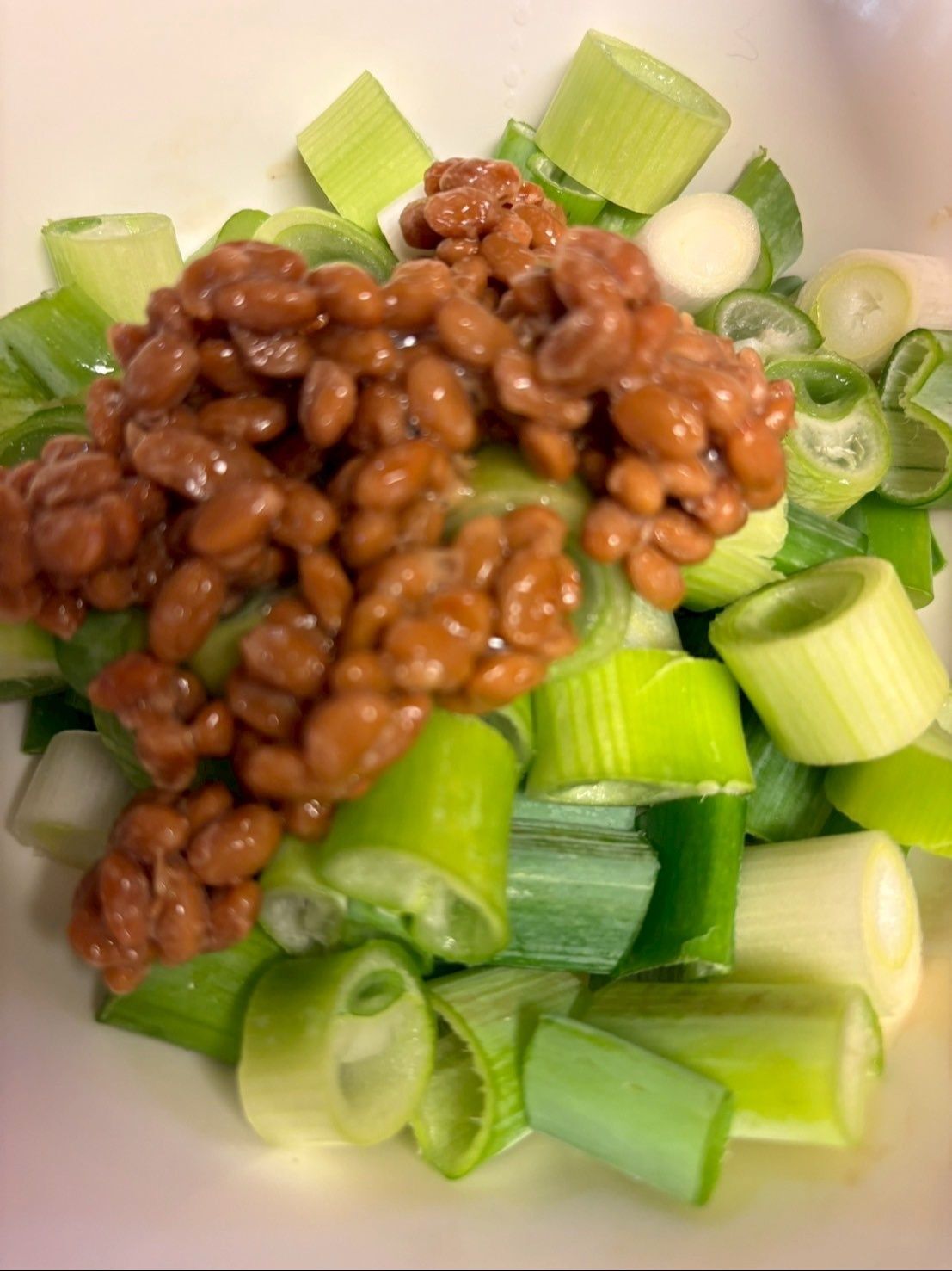 ネギは1cmくらいのぶつ切りにして納豆を加えます