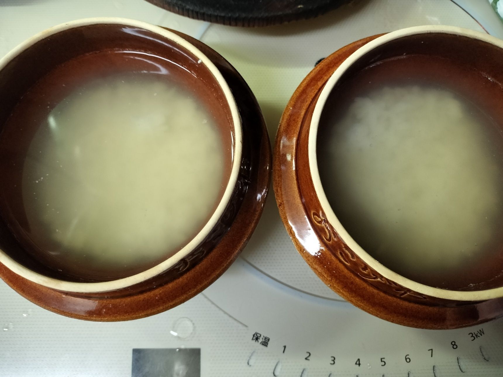 3. 1人用の釜飯用の釜（2つ）に、白飯と手順2の煮汁・ほぐした肩肉を半分ずつ入れる→蓋をする