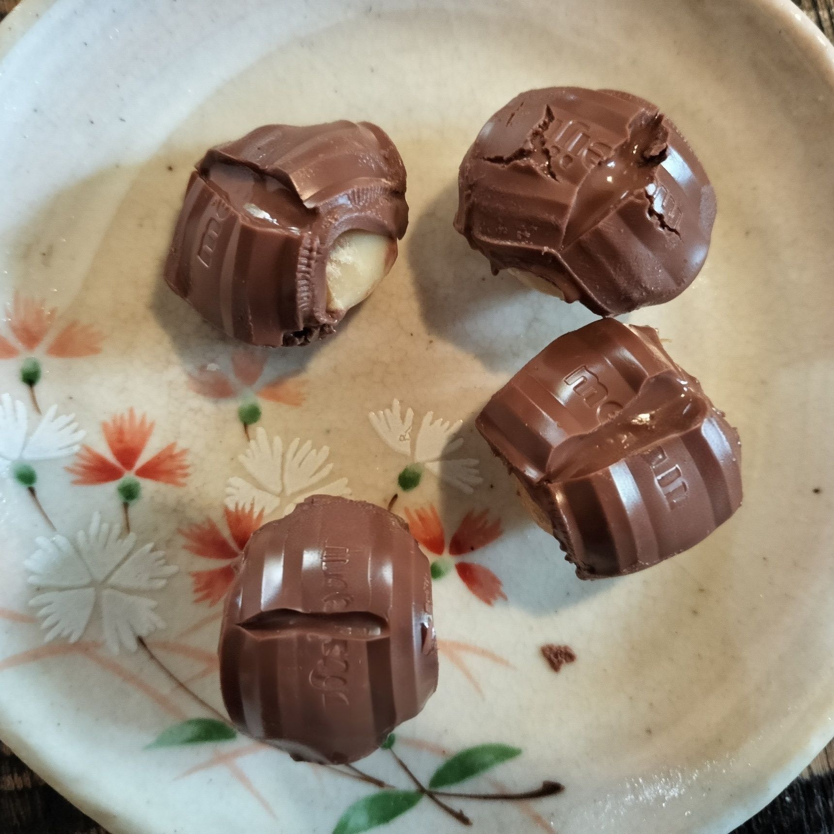 3、程よく溶けたチョコレートの四隅を優しく押さえて、マカダミアナッツを包む