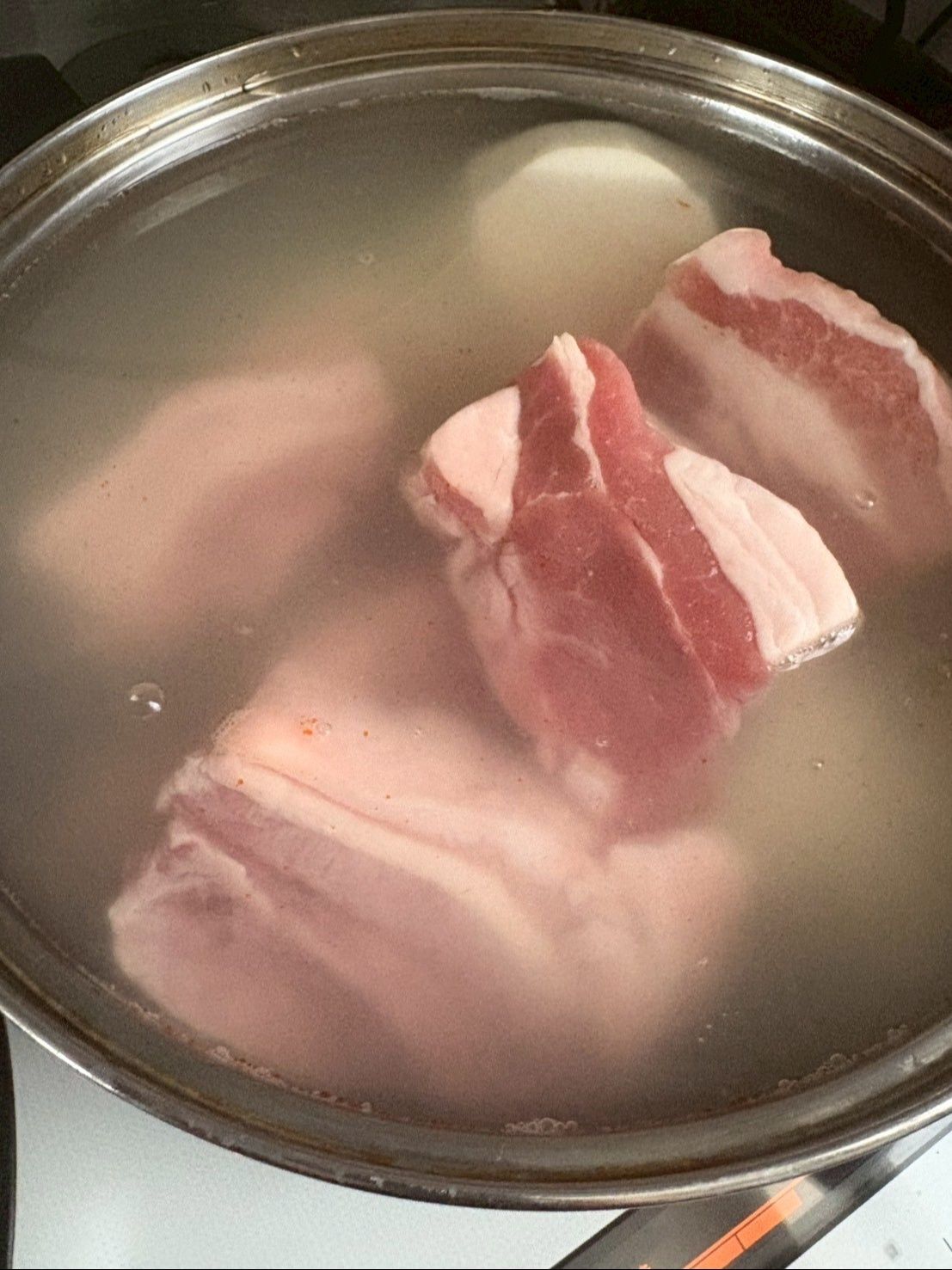米の研ぎ汁に塩を入れて豚肉、大根、じゃがいも、にんじんを下煮します。