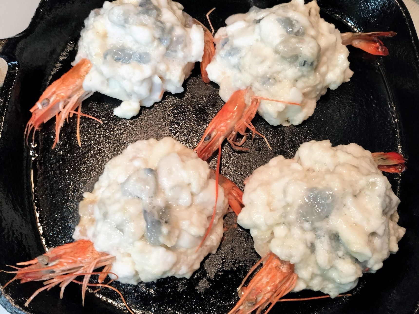 4、熱した鉄フライパンに、ごま油を入れ、中火にする→真薯生地を、1/8量ずつ4箇所に入れる→手順2の海老の頭と尾付き海老の身をのせる→海老の頭と尾が隠れないように、真薯生地を1/8量ずつのせる→両面をこんがり香ばしく焼く