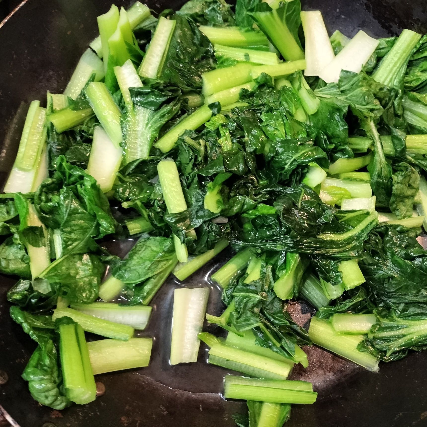 5、別の鉄フライパンを熱し、ごま油を入れる→食べやすい大きさに切ったターツァイを入れる→強火でサッと炒める→手順4の具材を加える