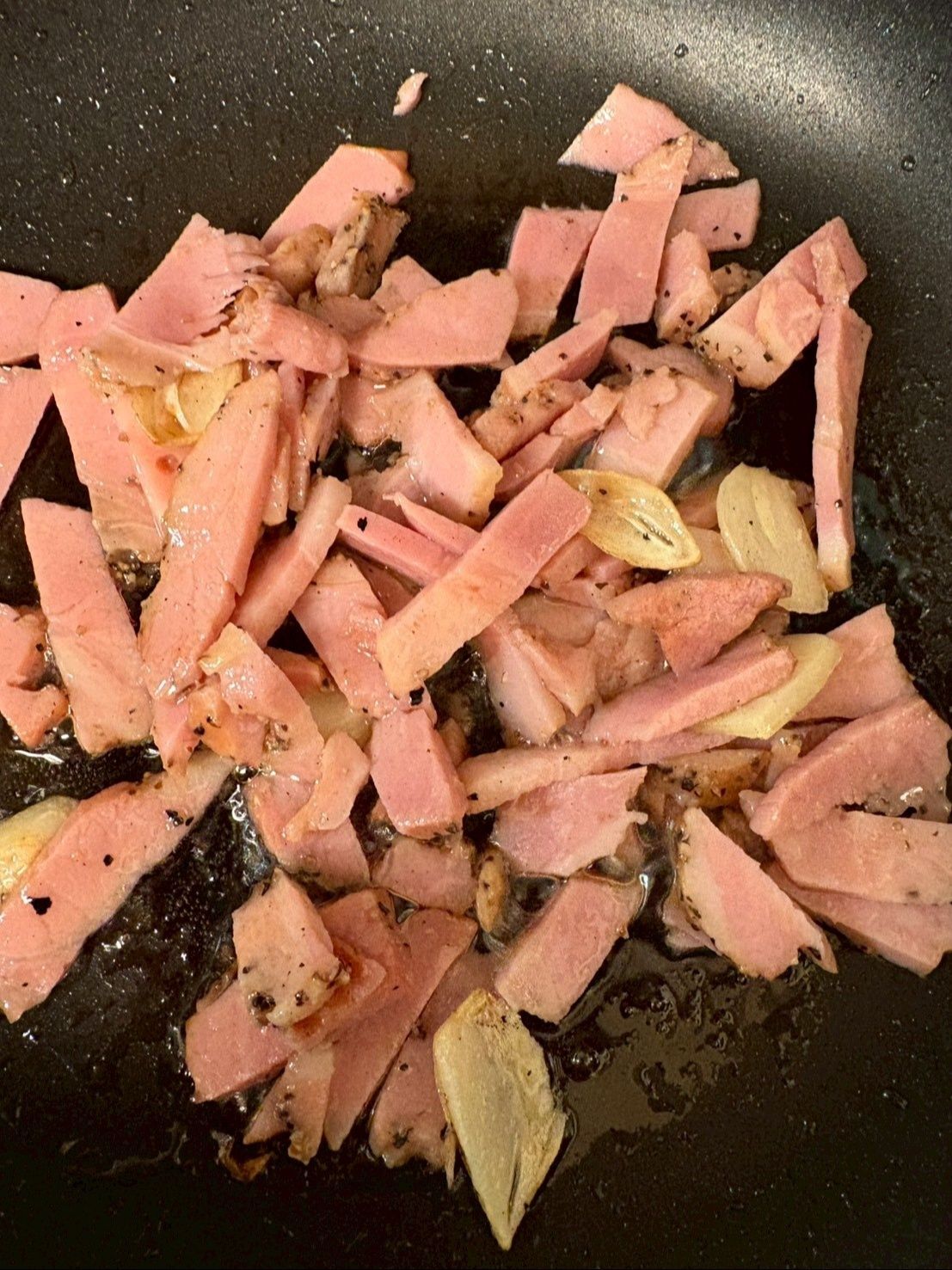 ニンニクがパリパリになる前にベーコンも入れてしまいます。