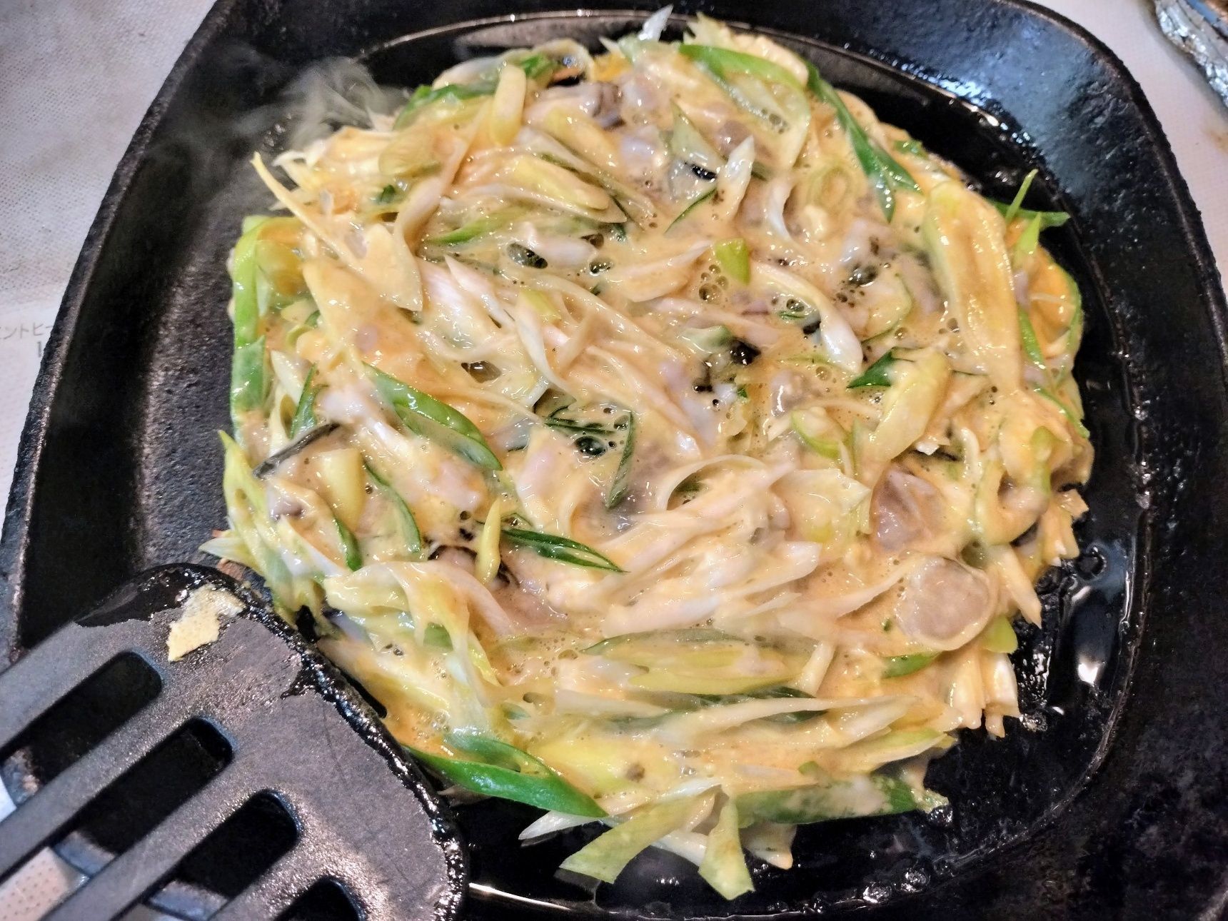 3.熱した鉄フライパンに、ごま油を入れて、お好み焼き生地を広げる→中火で3分程焼く→ひっくり返して、蓋をする→中火で3分ほど蒸し焼きする→蓋を取る→仕上げに、両面を焼き、カリッと香ばしく仕上げる