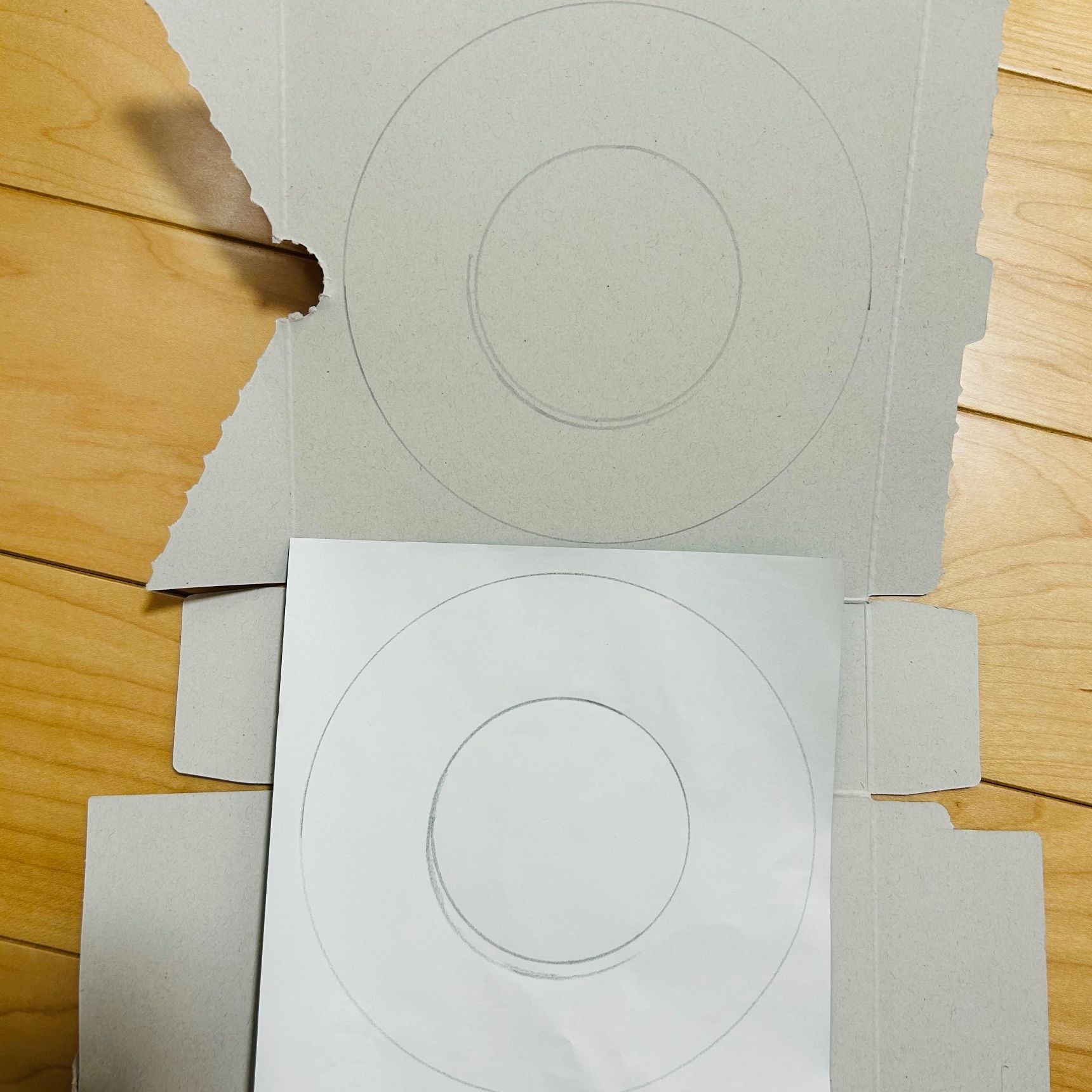 ②厚紙と折り紙をリース型に書き、はさみで切ります