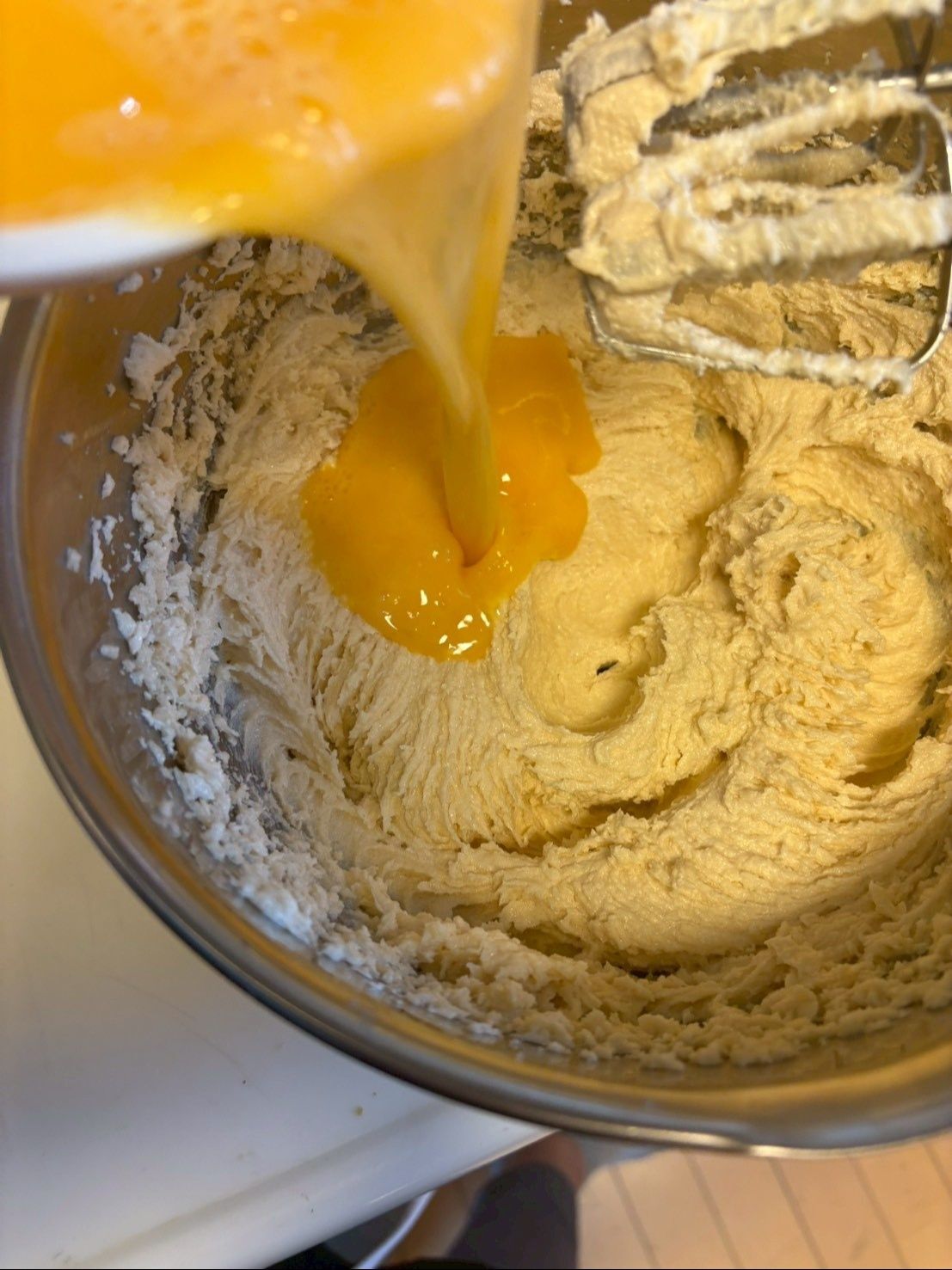 割りほぐした卵を5～6回に分けてふんわり混ぜ合わせます。