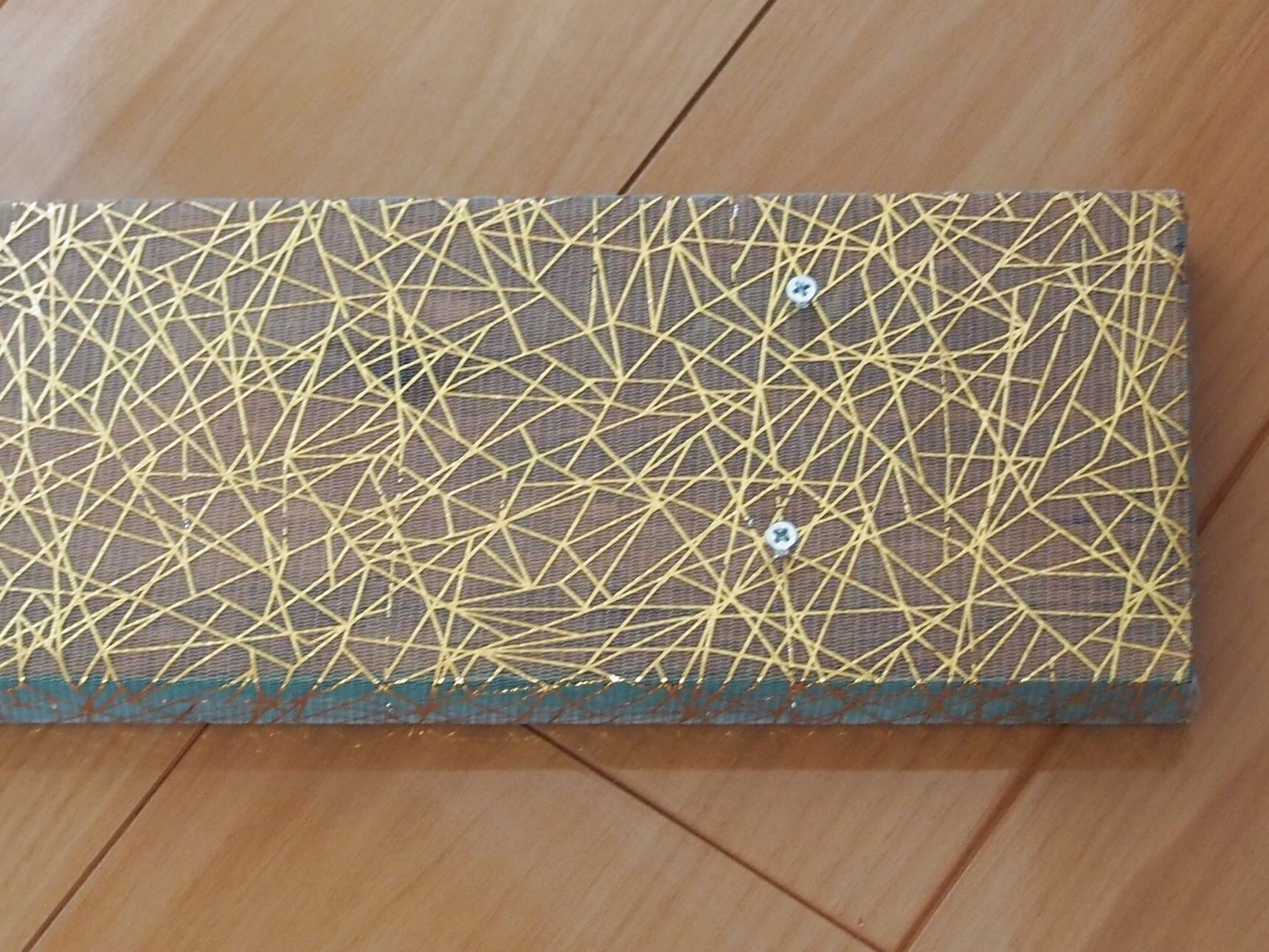 ねじを挿しこんで皿の上に接着剤を塗り、プレートを固定します