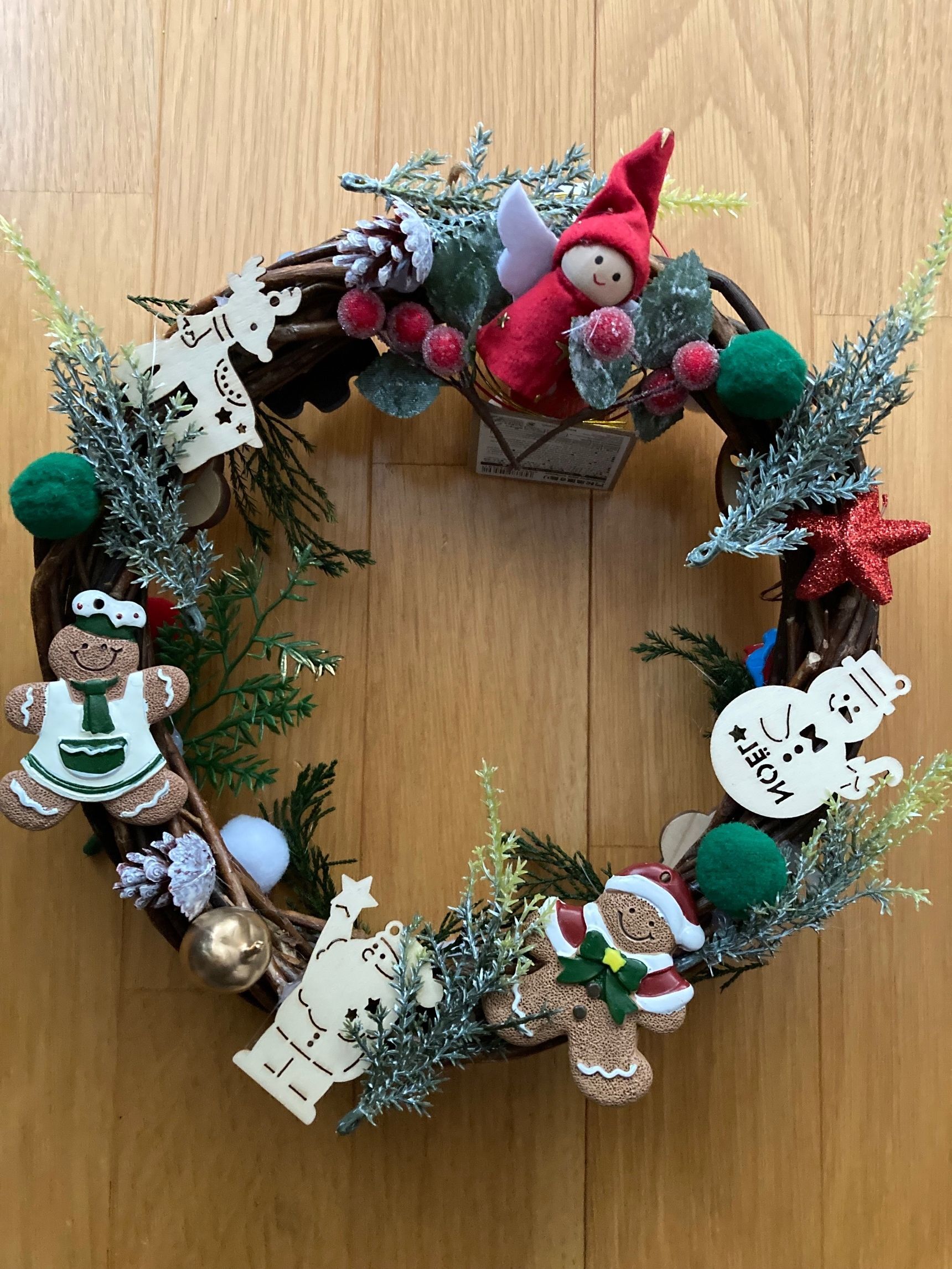 ③クリスマスリースに、花材を付けて、裏面の飾りが見えないようにする。