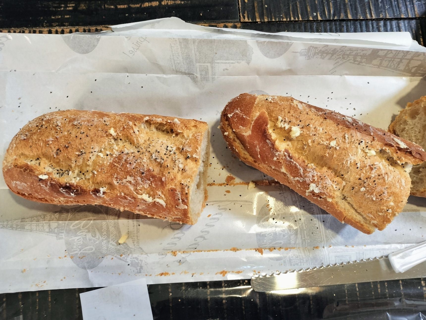 2、市販のフランスパンを食べる分だけ、切り分ける→切り込みを入れ、適当な大きさに切った発酵バターを数カ所に入れる→表面（全面）に発酵バターを塗り、粗挽き胡椒をかける→トースターで2分程炙る