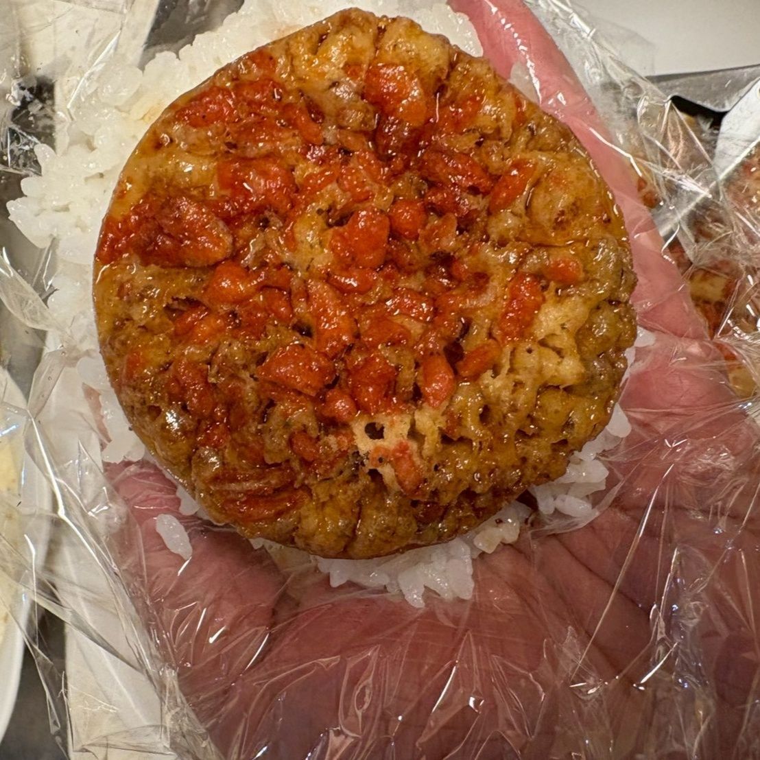 ラップにご飯を乗せ、タレに浸けたえび天を乗せます。