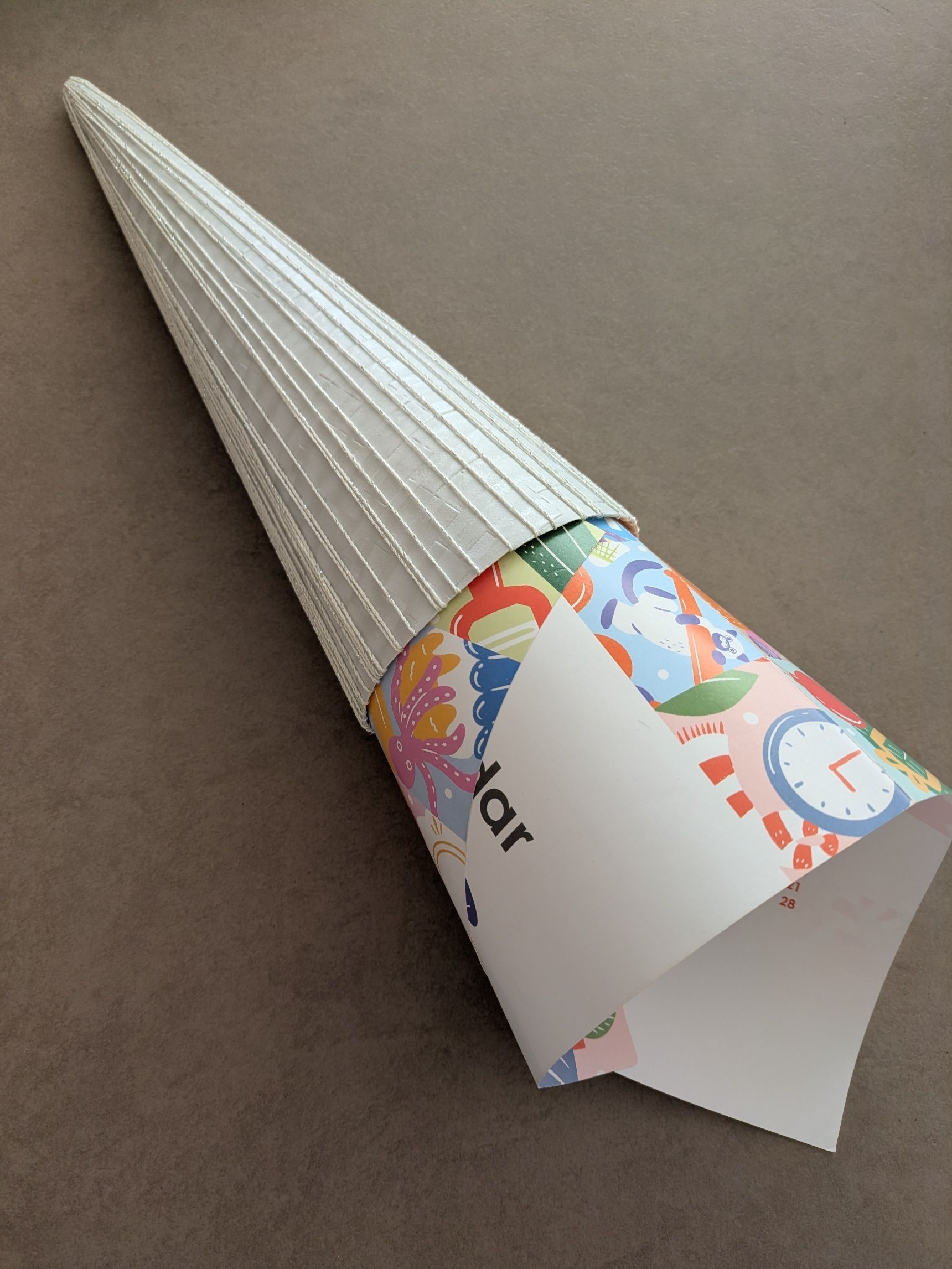 今回は、もう少し高さが欲しかったので、今のサイズより大きな三角錐ができるサイズの紙（カレンダー）を丸めて突っ込み、バランスのいいサイズ感に切り取る。