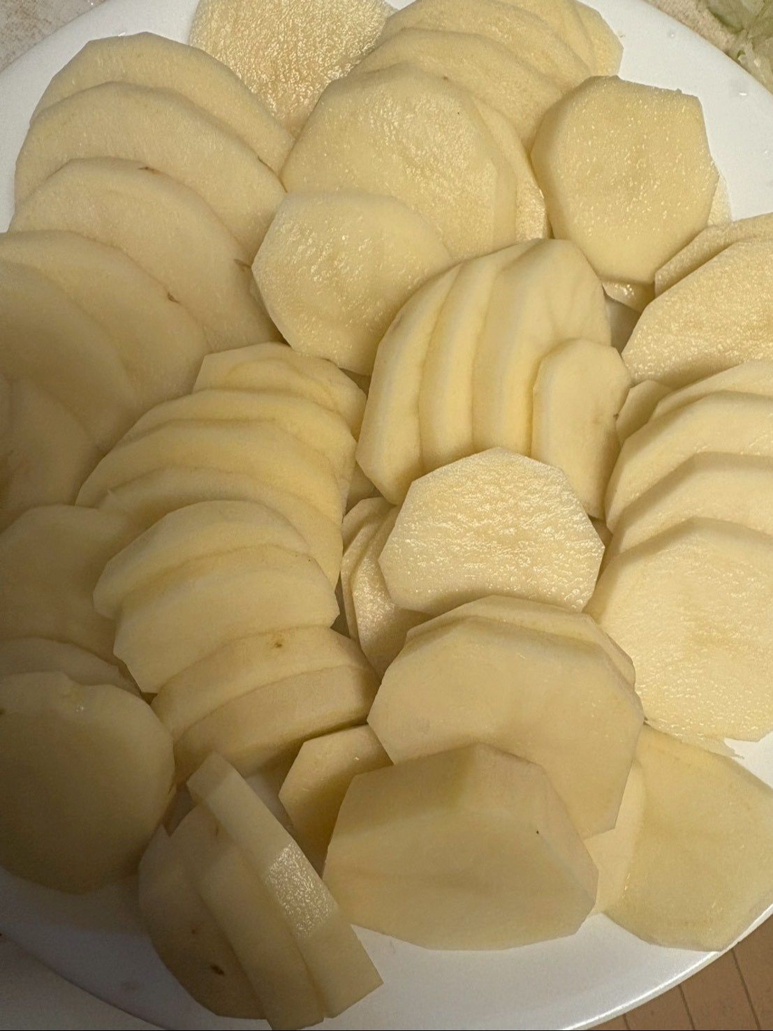 ジャガイモは皮を剥き1cmくらいの厚さに切ったらラップをしてレンチンします。