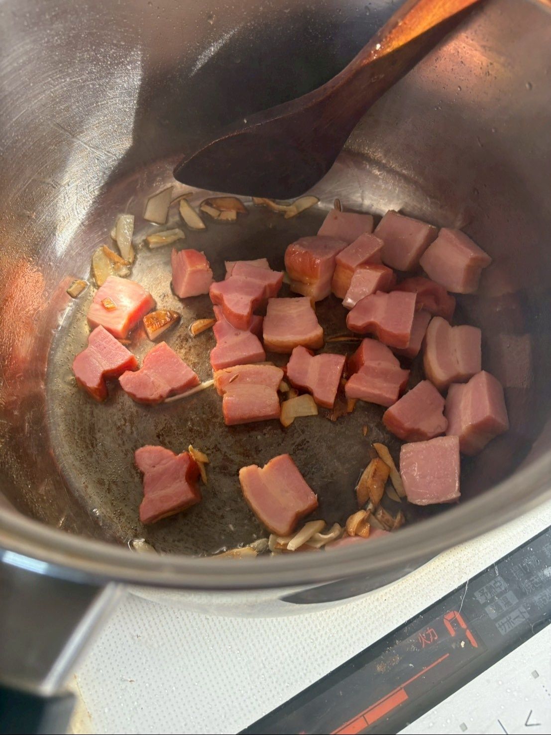 鍋にオリーブオイルを入れ、にんにくのみじん切りとベーコンを炒めます。