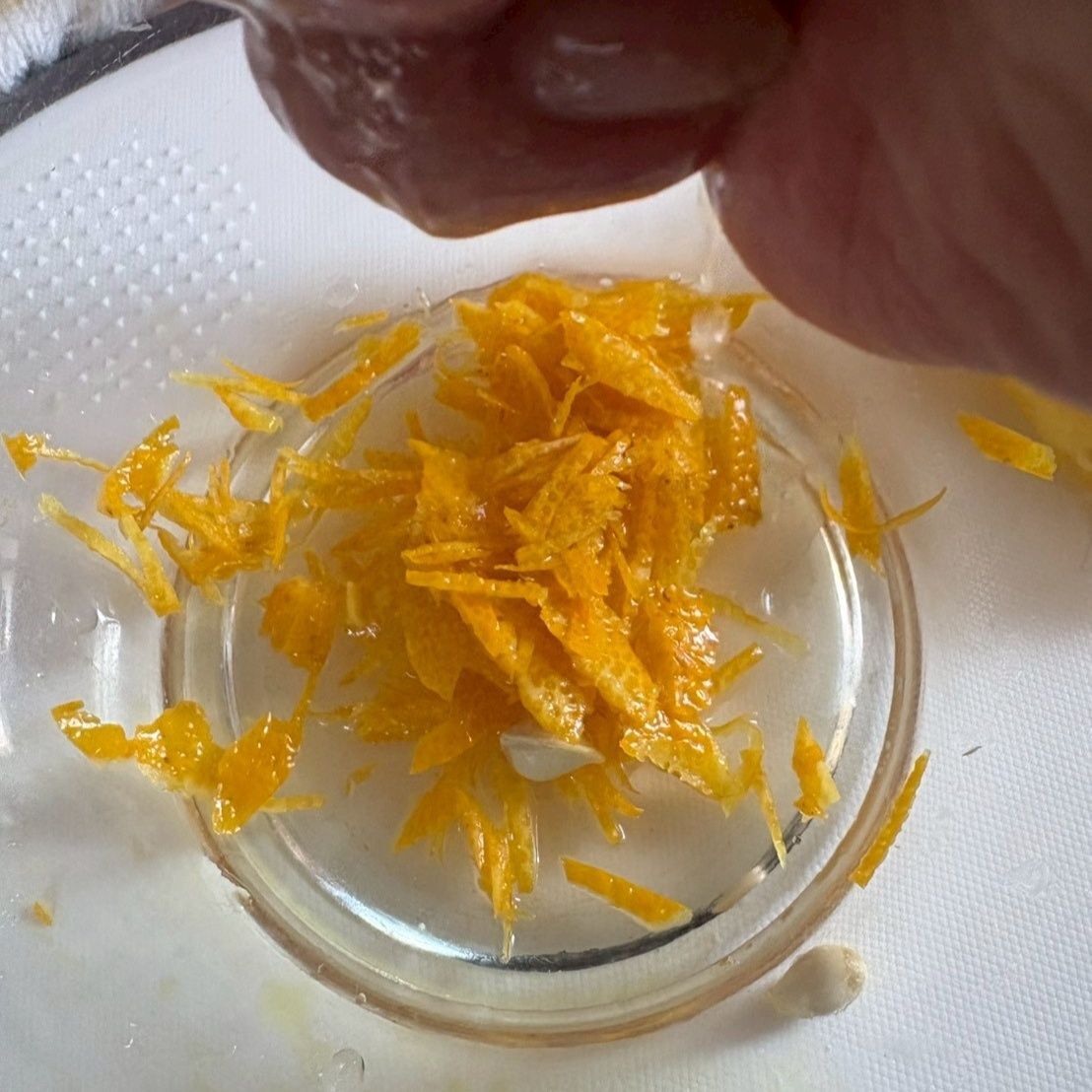 柚子の皮を剥き、細く刻んで果汁を絞ります