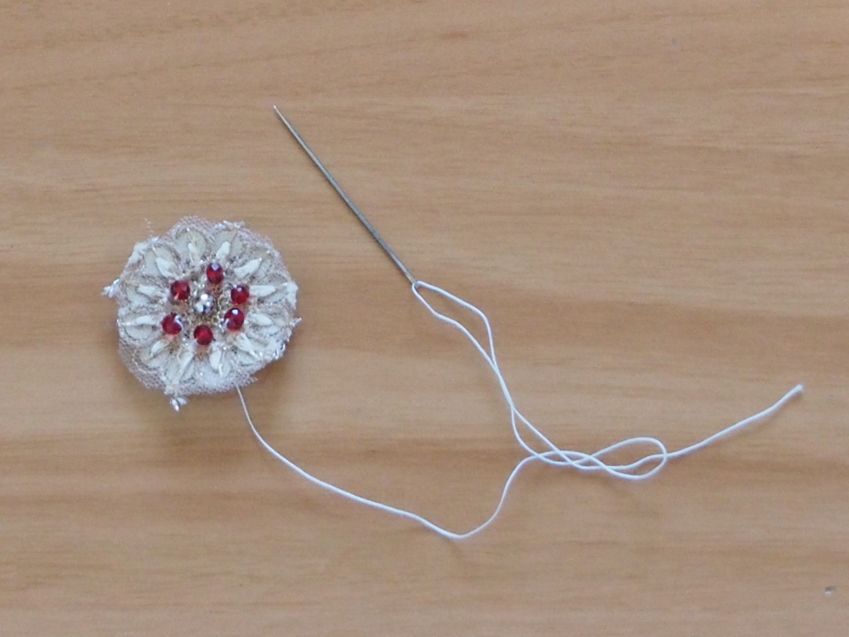 刺繍リボンの花柄をハサミで切って、、、糸でビーズを付けます