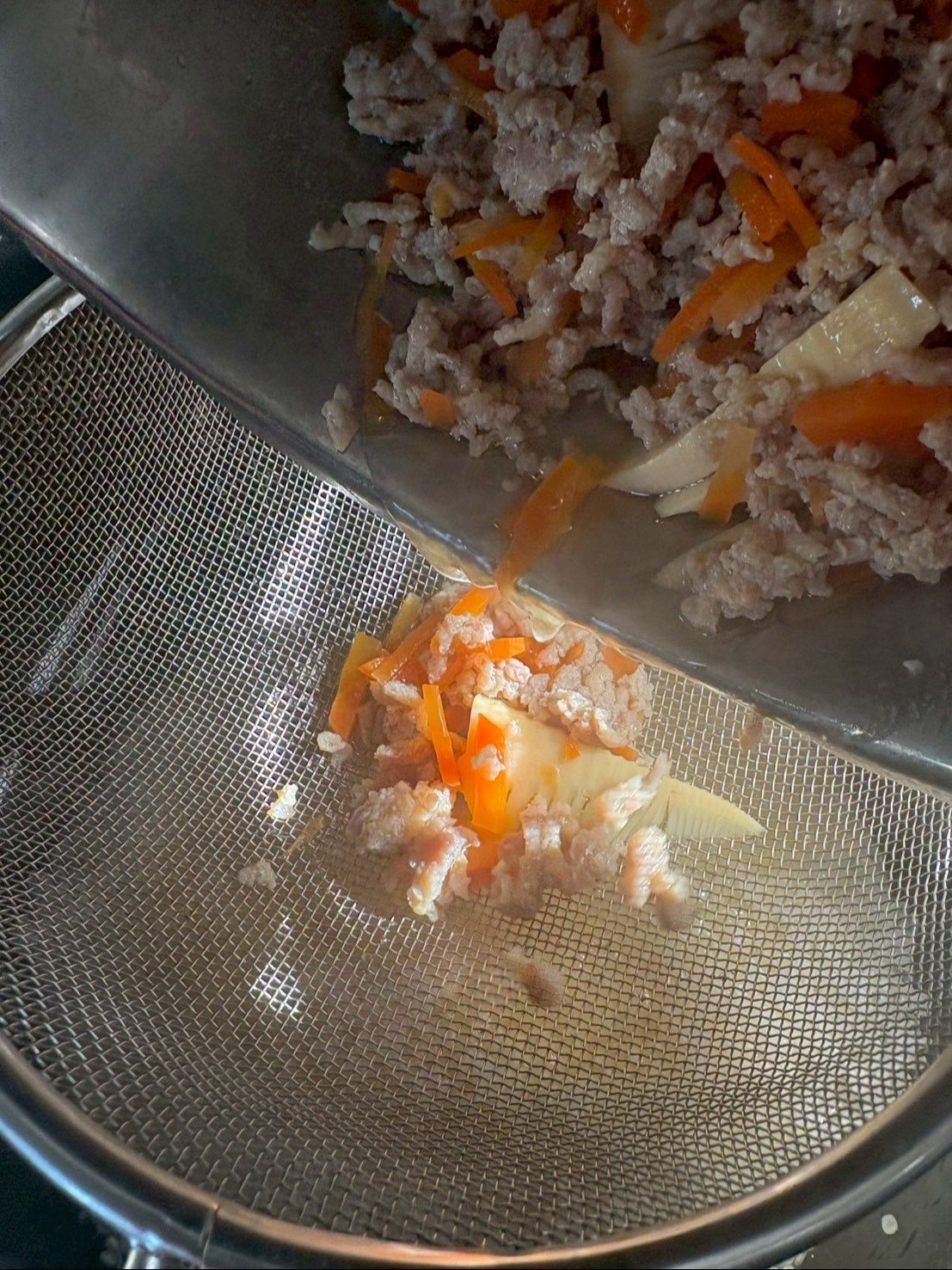 米のい入った内釜にザルを通して具材の煮汁だけを入れます