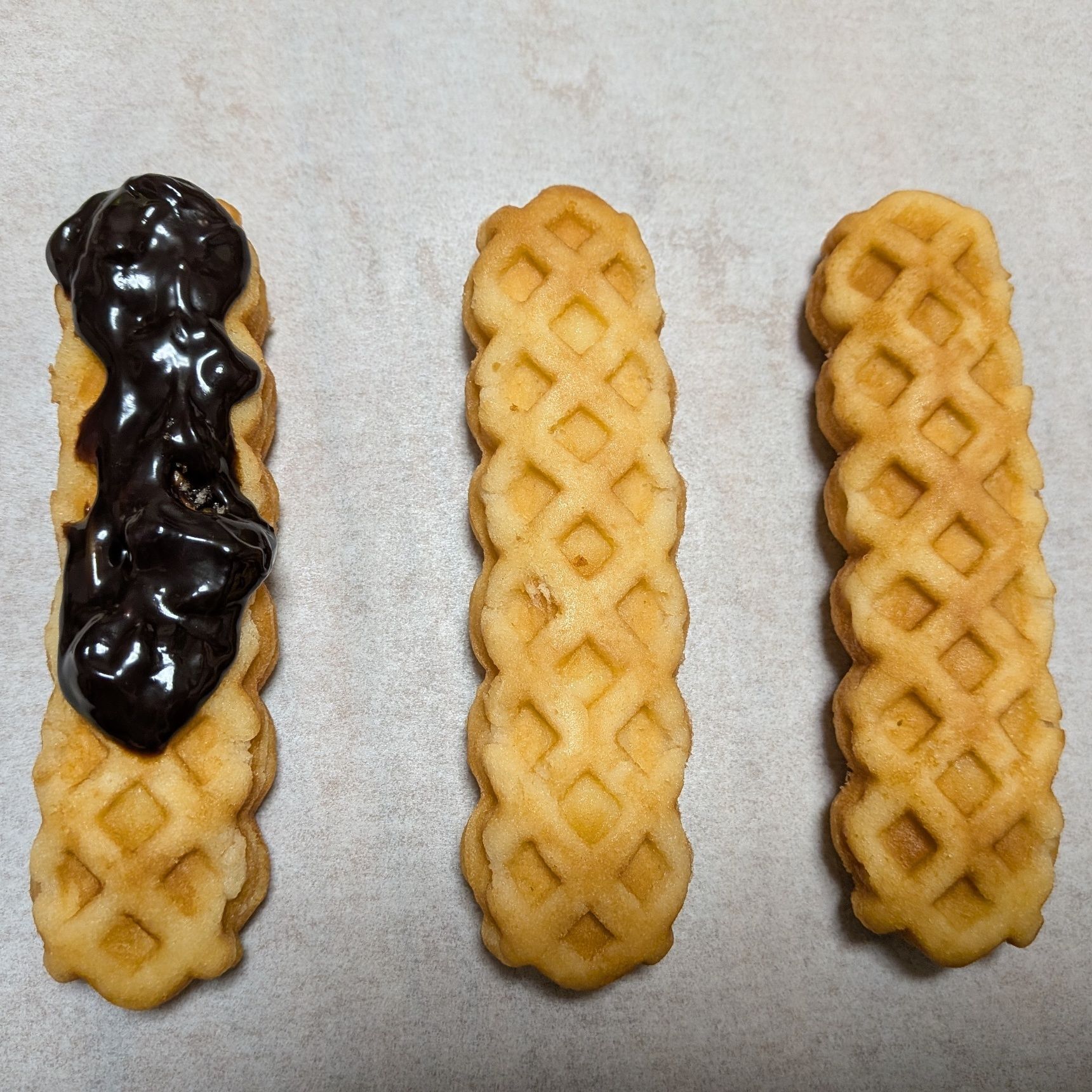 1、チーズドッグを並べる。チョコレートクリームを練って柔らかくし、上からスプーンでのせていく。