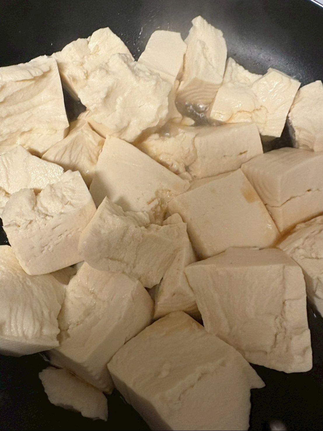 フライパンにごま油を入れ、手で大雑把にちぎった豆腐をよく炒めます。