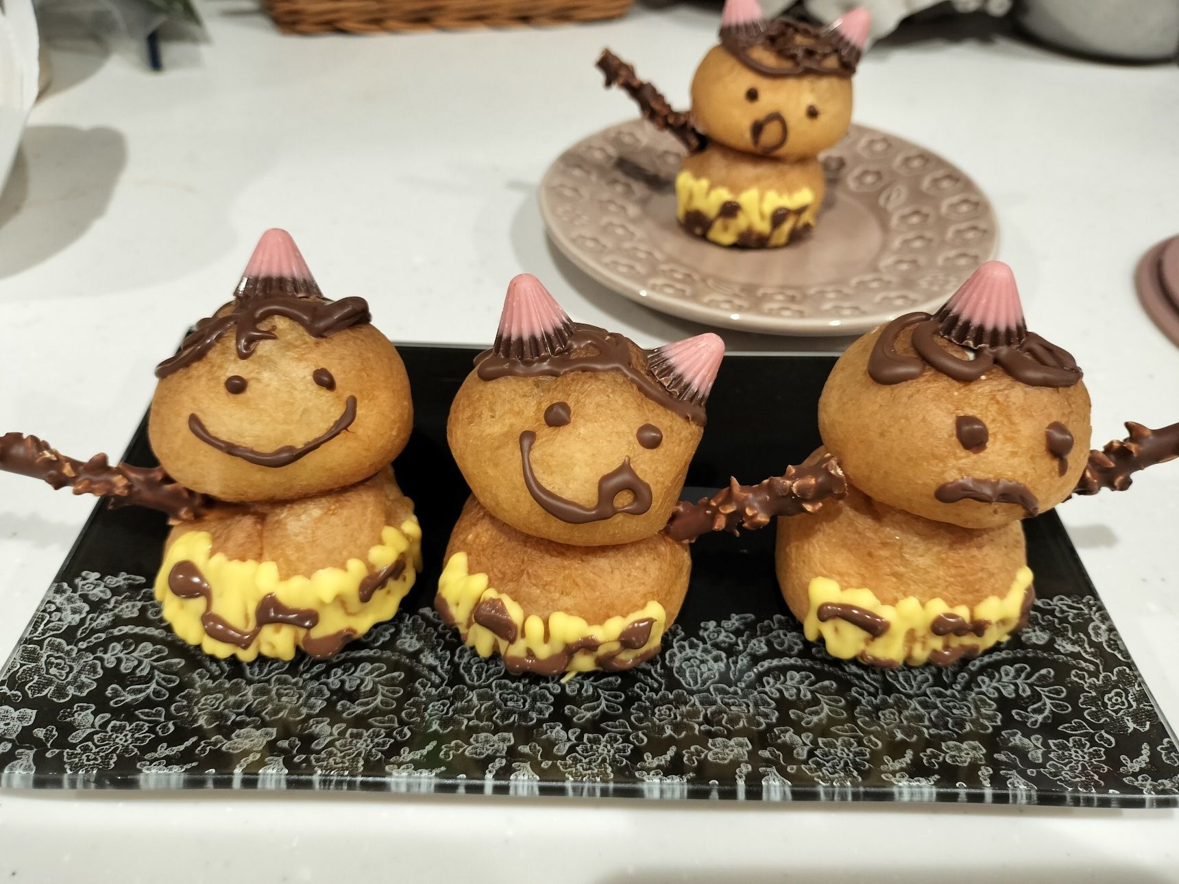 2つのシュークリームをチョコペンでくっつける。腕部分に穴を開けてから小枝かポッキーを折ったものを刺して金棒を持たせる。完成！