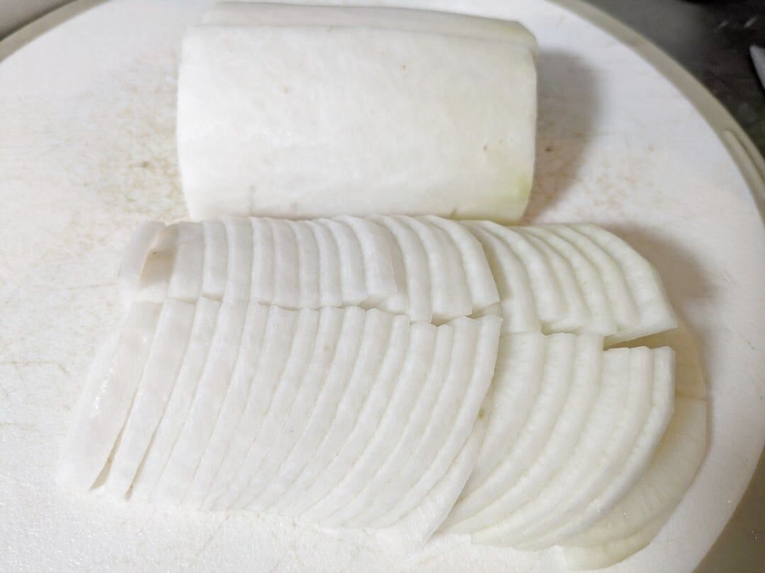 大根をイチョウ切りにする。